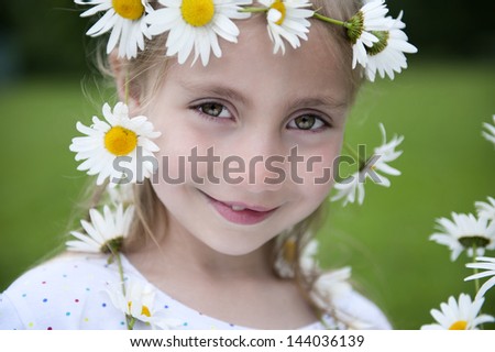 little blond girl with a crown of daisies in her hair
