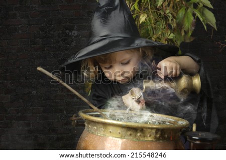 little halloween witch with cauldron, outdoors
