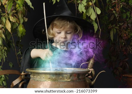 little halloween witch with cauldron, outdoors