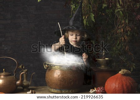 little halloween witch with boiling cauldron