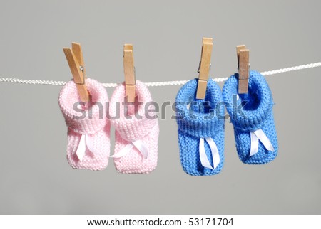 pregnancy concept: pink & blue baby booties hanging on a clothes line