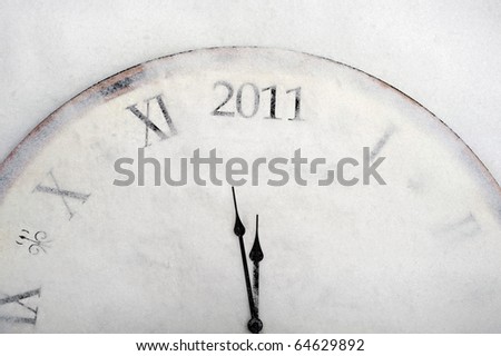 new year concept old vintage clock, covered by snow, showing 2011