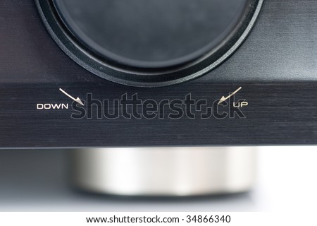 Closeup of an AV Receiver Volume knob, focus on the text indicating the direction to increase or decrease the volume.