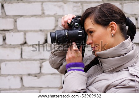 woman photographer on the background of a brick wall