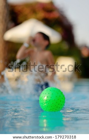 hot summer day, the boy in the pool with turquoise water played Ball