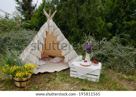 nature white tent on a bouquet of flowers and a box strawberries and milk