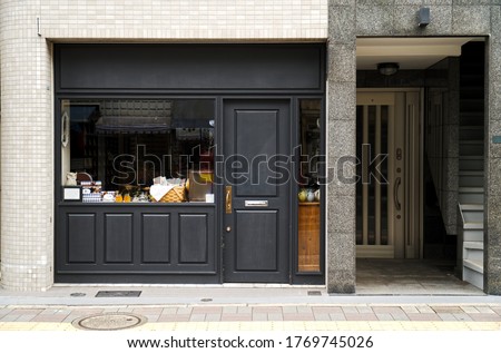 Outdoor mock up of store and shop front template - front view vintage black grey shop tone  with windows display, and tea making, doll decoration. Stockfoto © 