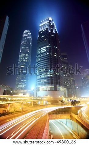 Hong Kong Business District at Night. Corporate building at the back and busy traffic across the main road at rush hour.