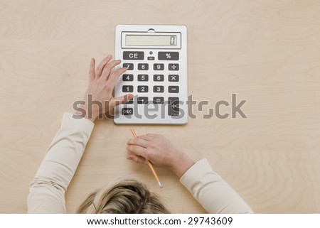 Balance at Zero - overhead shot of hands using calculator and top of woman\'s head in frame