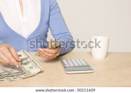 desk with cash, calculator,  and coffee cup