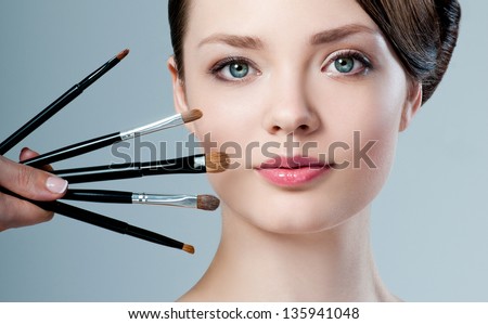 beautiful woman. Makeup brushes.