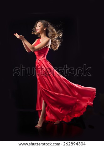 Young beauty woman in red waving flying  dress. Dancer in silk dress.