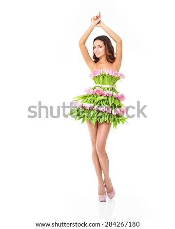 Beautiful woman in a dress of flowers. Pink tulips. Spring flowers.