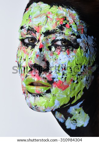 Woman face with professional makeup, bright colors. close up portrait. Face paint smears.