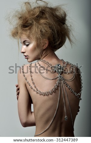 Beautiful woman with magnificent hairstyle. Great decoration on the back, body Chain