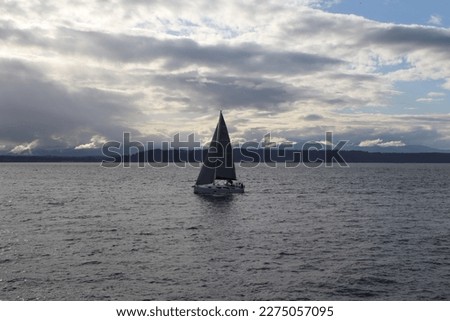 Similar – Image, Stock Photo Lonely yacht in gray water with dark mountains under cloudy sky