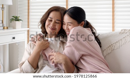 Candid attractive beautiful mum sit at cozy sofa couch living room in family moment grown child kid celebrate joy good warm time kiss relationship with retired overjoy lady girl health life insurance. Stock foto © 