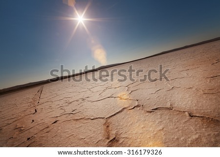 Dry lake under a blue sky and a bright sun