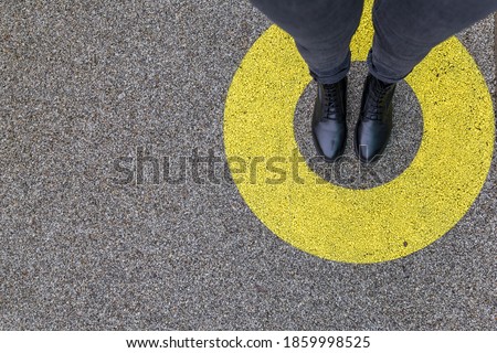 Black shoes standing in yellow circle on the asphalt concrete floor. Comfort zone or frame concept. Feet standing inside comfort zone circle. Place for text, banner Imagine de stoc © 