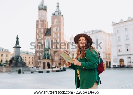 Foto Bild Junge Reisende in den Straßen einer Altstadt in der Toskana, Italien, bewundert die Blumendekoration am Gebäude