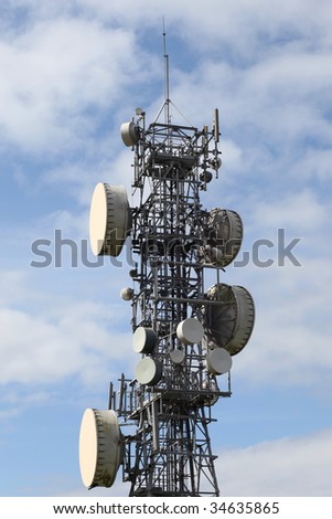 Microwave antennas mounted on a steel mast against a blue sky