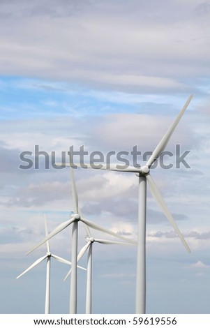 Four giant 2 megawatt wind turbines in sunlight with lots of copy space above
