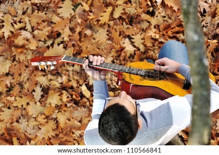Young man with guitar in park