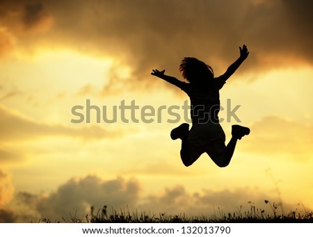 Active little boy jumping and having happy time on summer meadow by sunset