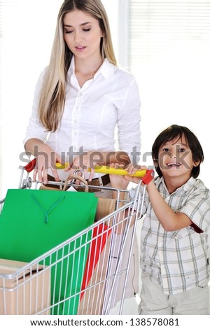 Happy mother with her kid shopping using basket