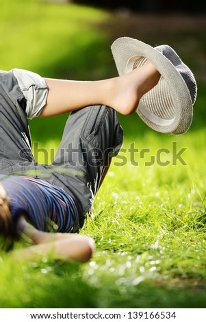 Relaxed kid resting on summer park grass meadow