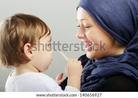 Arabic Muslim mother playing and taking care of her baby