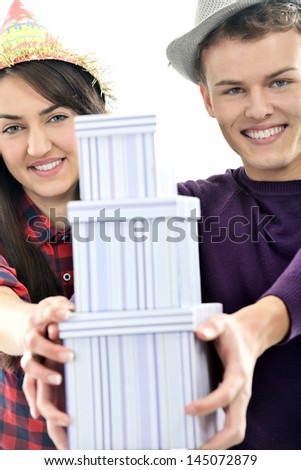 Two happy young people with hats isolated on white holding three boxes