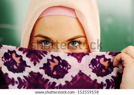 Muslim Arabic teenage student inside the high school classroom posing