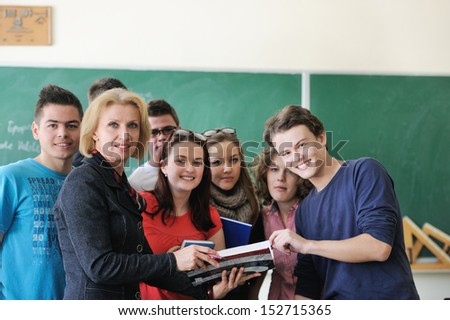 Teacher holding a book standing with students