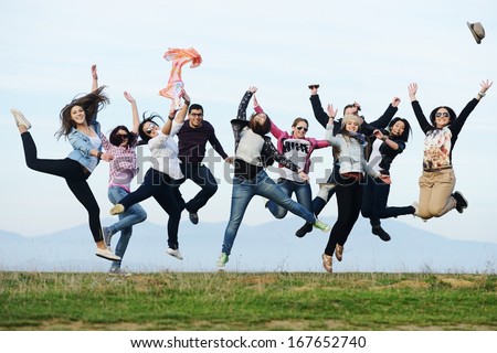 Happy teen girls having good fun time outdoors jumping up in air