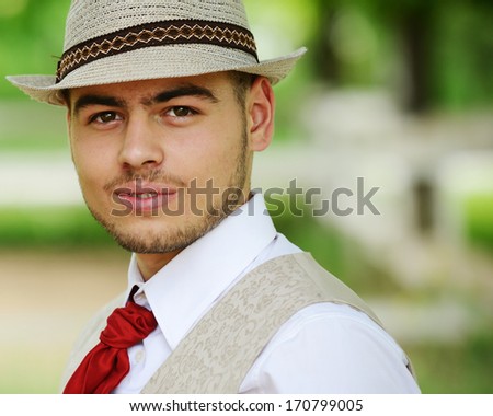 Young stylish man wearing hat shirt and tie in sunny day