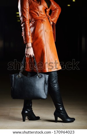 Young beautiful woman posing with fashionable leather clothes