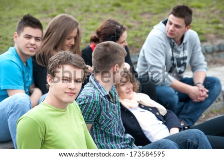 Group of happy students sitting in the park