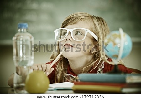 Cheerful instagram filtered little girl at school room having education activity