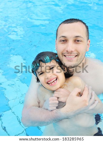 Father and son swimming in water pool at summer