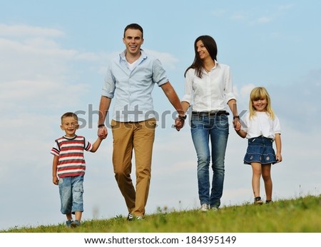 Young family on green summer grass meadow having happy life