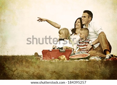 Nostalgic retro image of a young family with kids having picnic on green grass meadow in nature