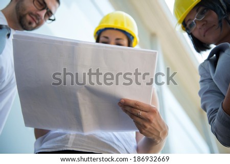 Business woman reading papers wearing hard hat