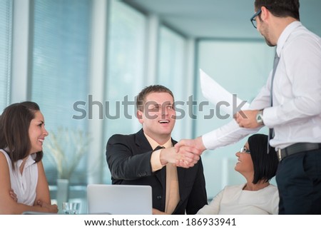Business men finishing agreement by shaking hands in corporate environment