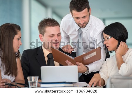 Four young people in office reading together
