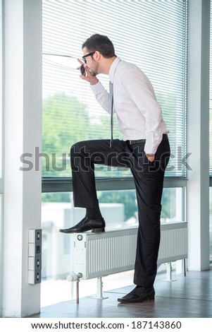 Business man waiting by window in modern office