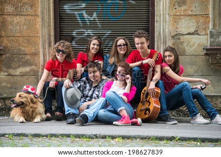 Group of trendy boys and girls posing outdoors