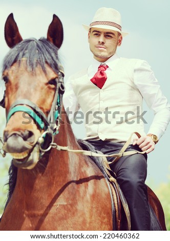 Happy young man on countryside with horse for riding