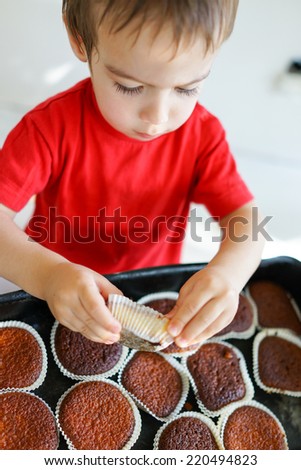 Cute kid helping in making cupcake with shallow depth of field