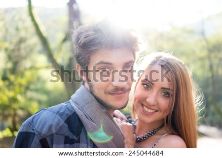 Young couple enjoying in beautiful park at river